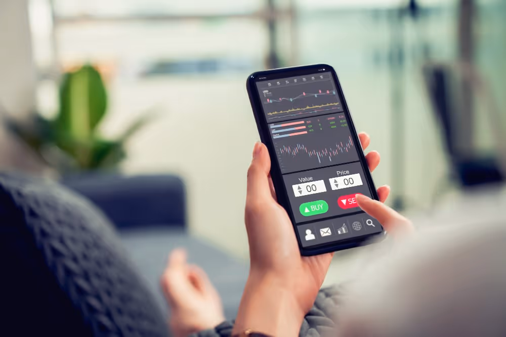 Graphiques boursiers consultés sur un téléphone, illustration de la sélection d’actions pour un PEA.