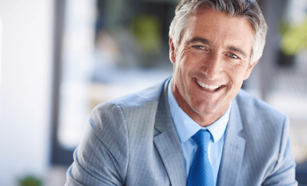 Portrait d’un homme en costume dans un bureau, illustration de la transmission d’entreprise avec la loi Dutreil.