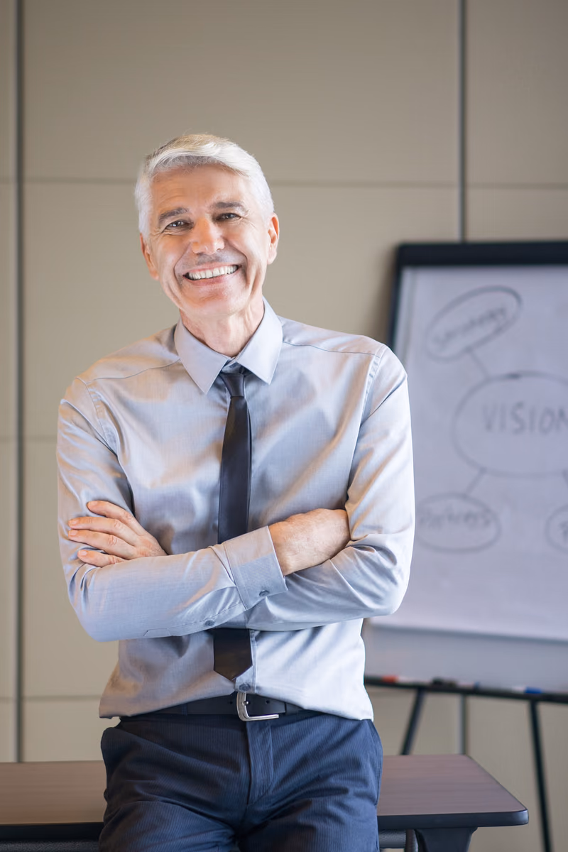 Un homme devant un tableau de présentation, illustration des étapes de préparation de la vente d’une entreprise.