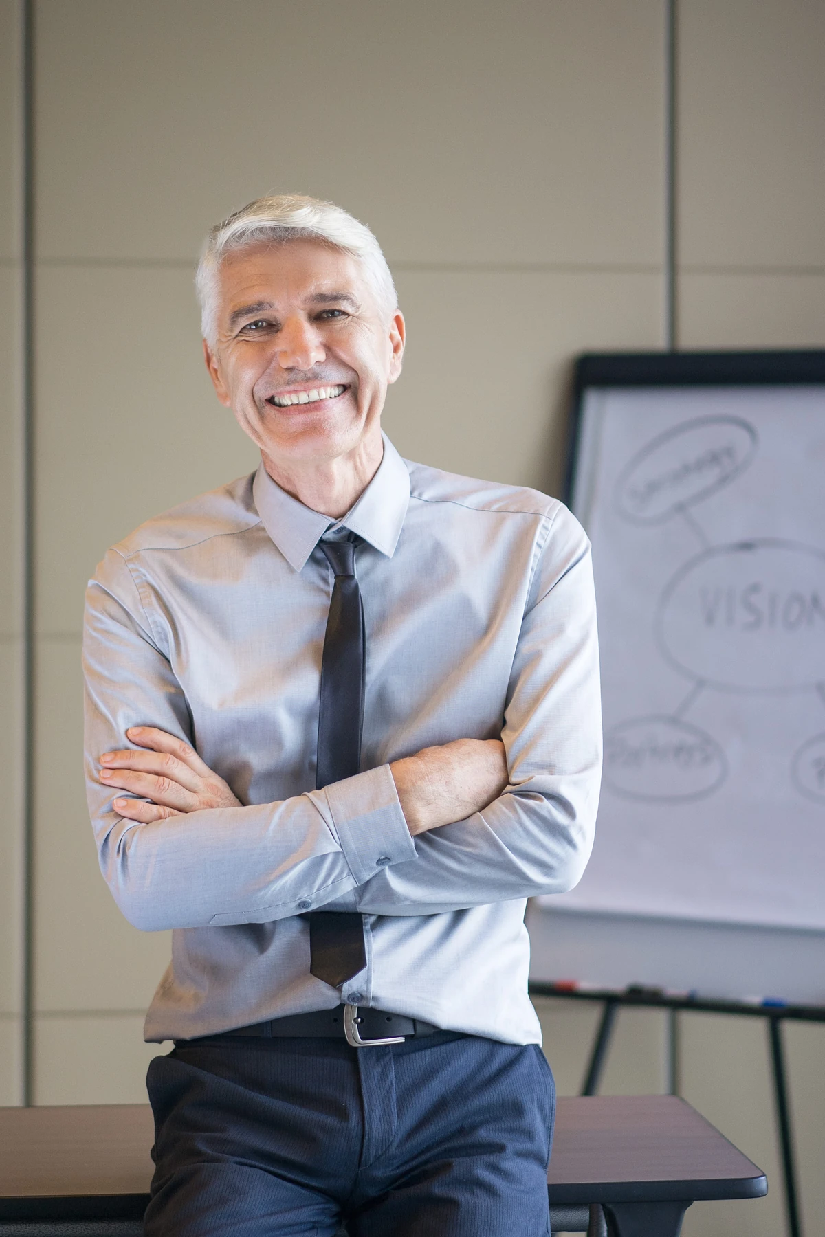 Un homme devant un tableau de présentation, illustration des étapes de préparation de la vente d’une entreprise.