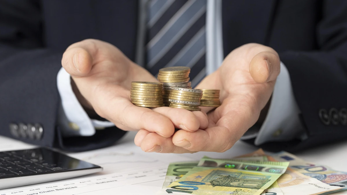 Piles de pièces et billets en euros, illustration des seuils de patrimoine et du ticket d’entrée en banque privée.