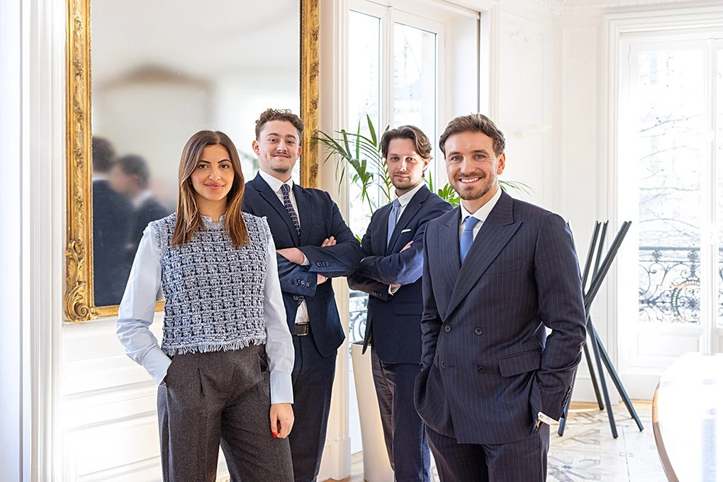Quatre personnes en tenue professionnelle dans un bureau, illustration de l’article sur le conseil en patrimoine gratuit.