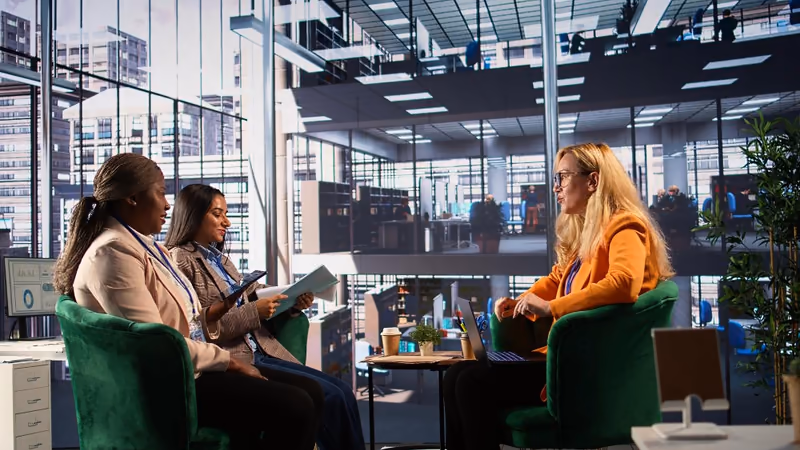Trois personnes échangent dans un espace de bureaux, illustration du plan d’épargne entreprise (PEE).