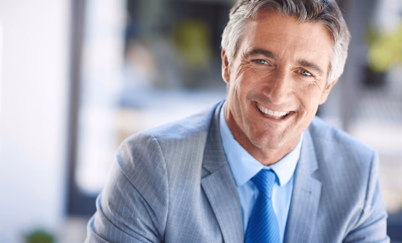Portrait d’un homme en costume dans un bureau, illustration de la transmission d’entreprise avec la loi Dutreil.
