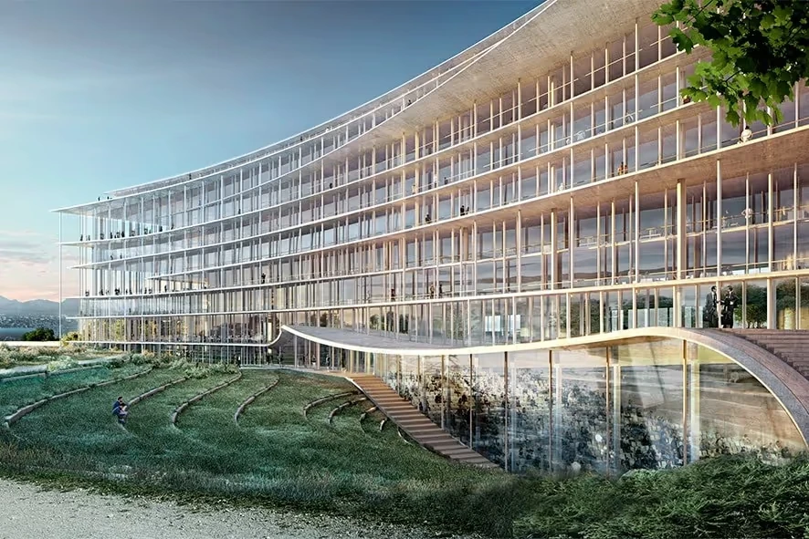 Façade vitrée d’un bâtiment entouré de verdure, illustration de l’article sur le ticket d’entrée chez Lombard Odier.