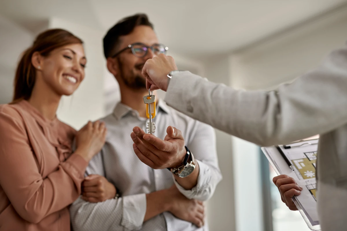 Un couple reçoit des clés dans un logement, illustration de l’article sur l’investissement en SCPI en nue-propriété.