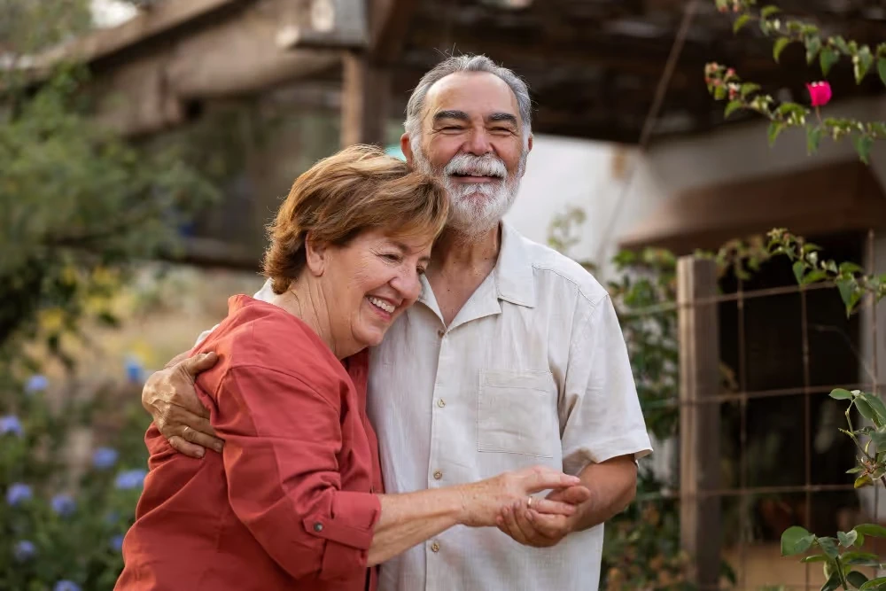 Un couple consulte un téléphone dans un jardin, illustration de l’article sur la donation d’une maison avec usufruit.