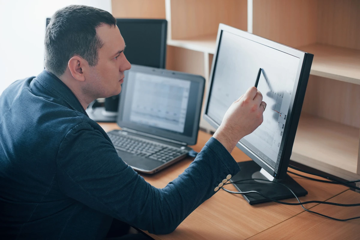 Un homme montre un graphique sur un écran, illustration de l’estimation du gain fiscal avec un simulateur PER.