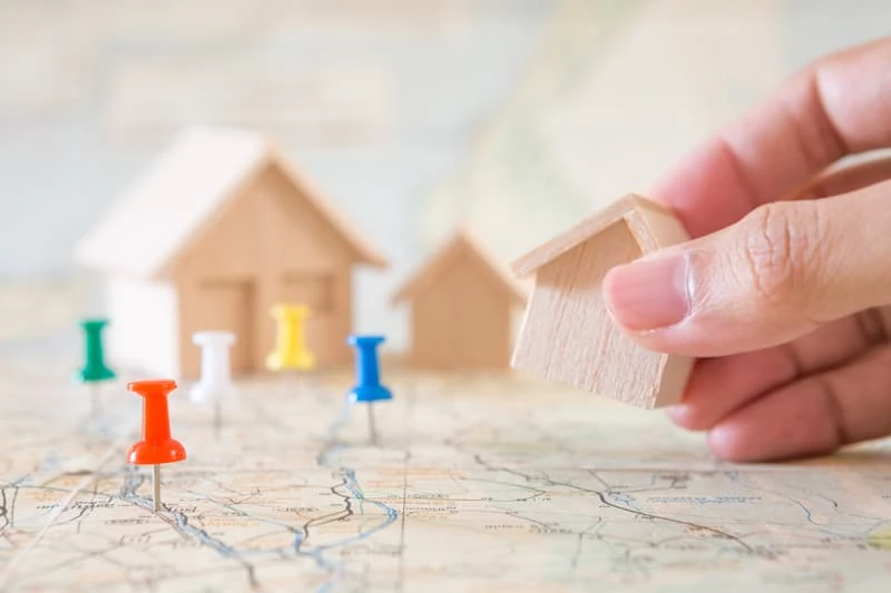 Une maison miniature placée sur une carte, illustration des critères de classement des SCPI.