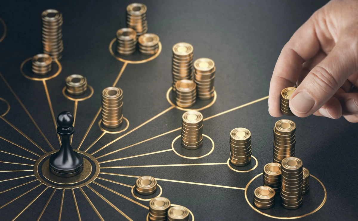 Pièces de monnaie reliées autour d’une pièce d’échecs, illustration d’une stratégie de gestion de fortune.