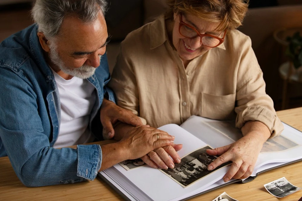 Un couple feuillette un album de photos, illustration de la transmission du patrimoine familial.