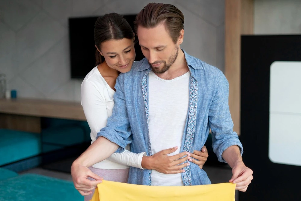 Un couple déplie un document, illustration de la donation entre époux pour organiser la protection du conjoint.