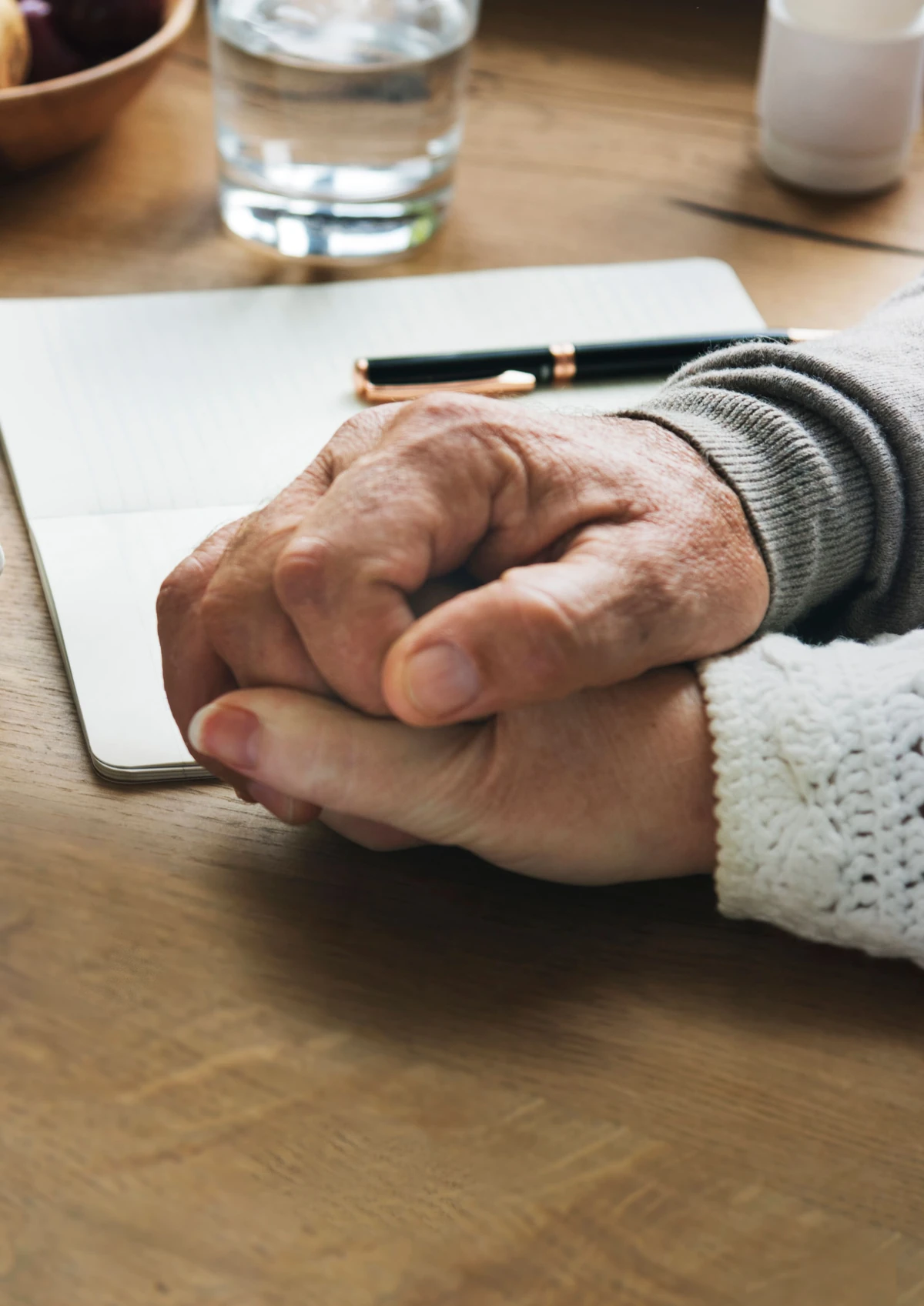 Deux personnes se tiennent les mains près d’un carnet, illustration de l’anticipation des frais de donation.