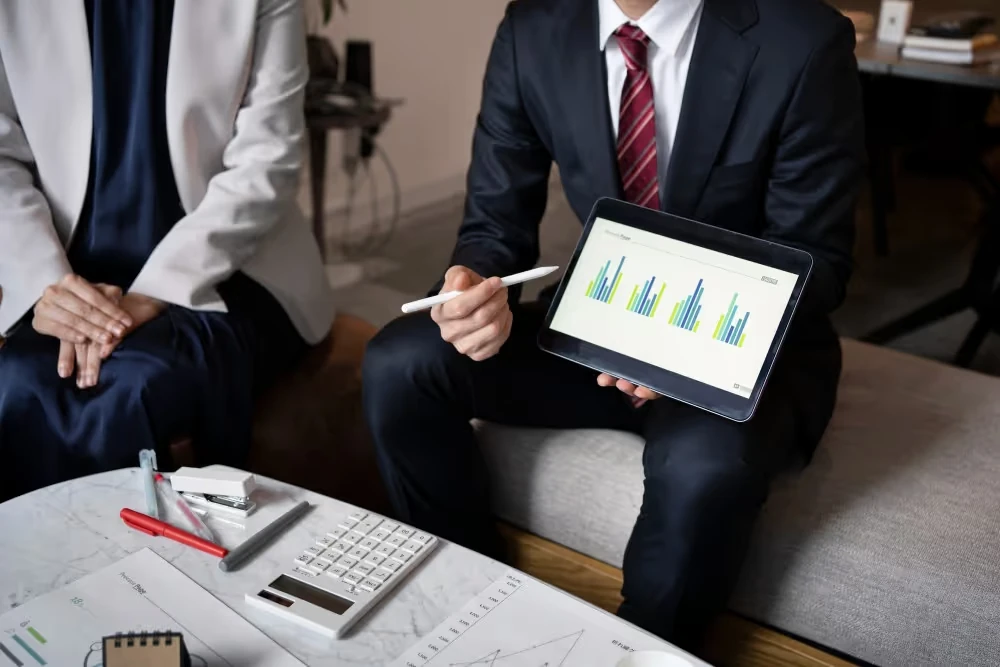 Présentation de graphiques sur une tablette lors d’un rendez-vous, illustration de l’investissement en private equity.