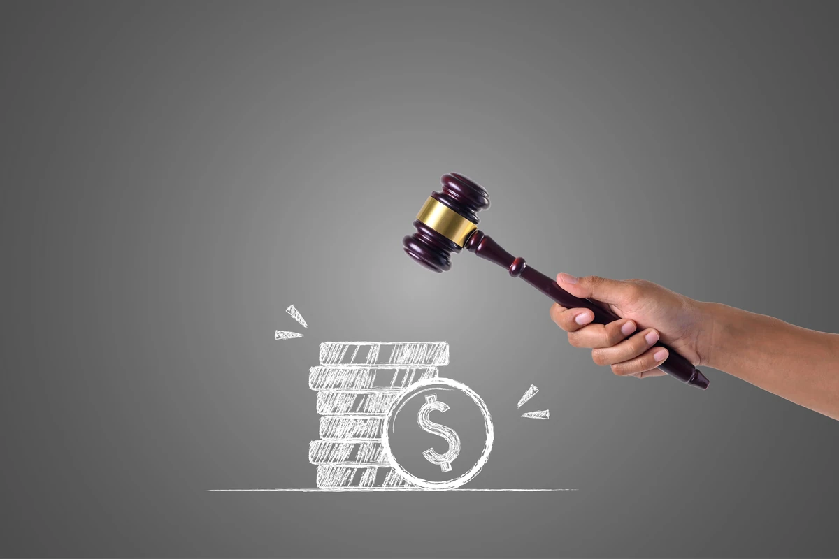 Marteau de juge et pièces de monnaie illustrant les règles de paiement des droits de succession.