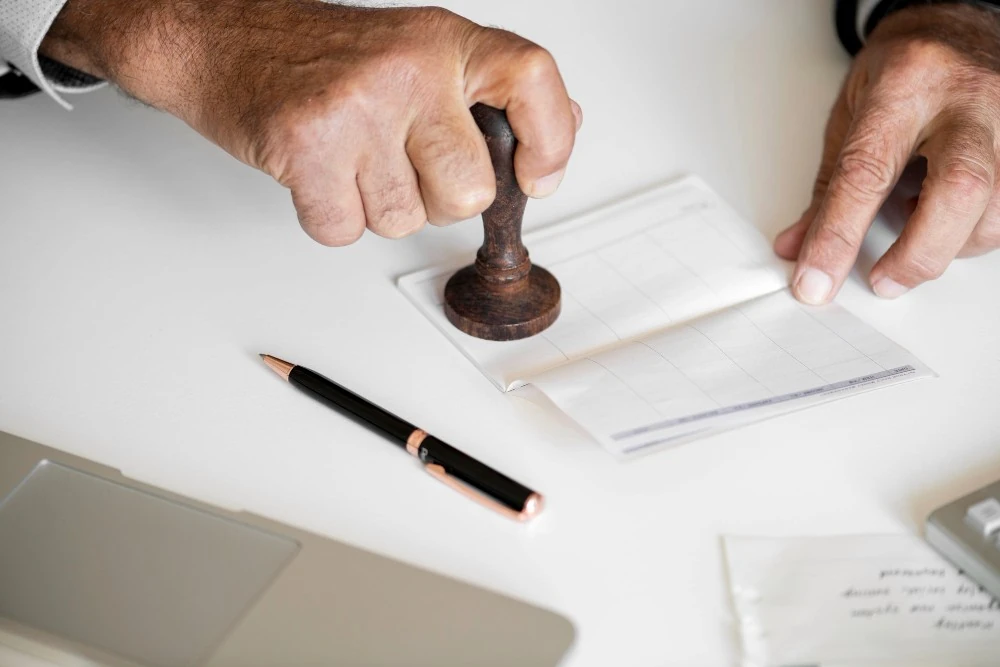 Un tampon apposé sur un document illustre les démarches d’obtention d’une attestation dévolutive.