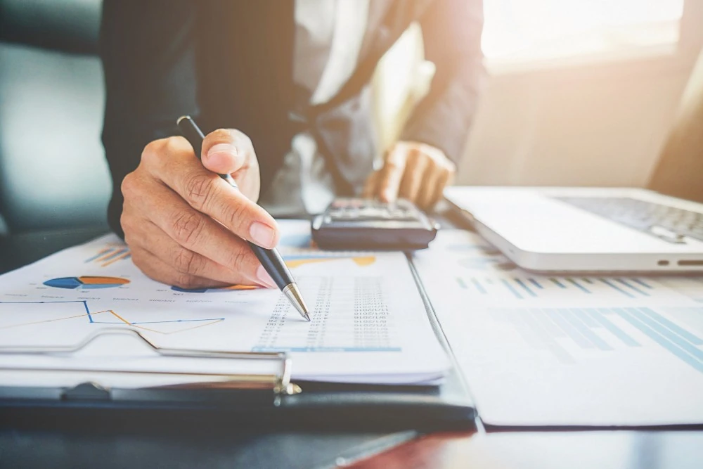 Graphiques imprimés et calculatrice illustrant l’analyse de la fiscalité de l’assurance vie.